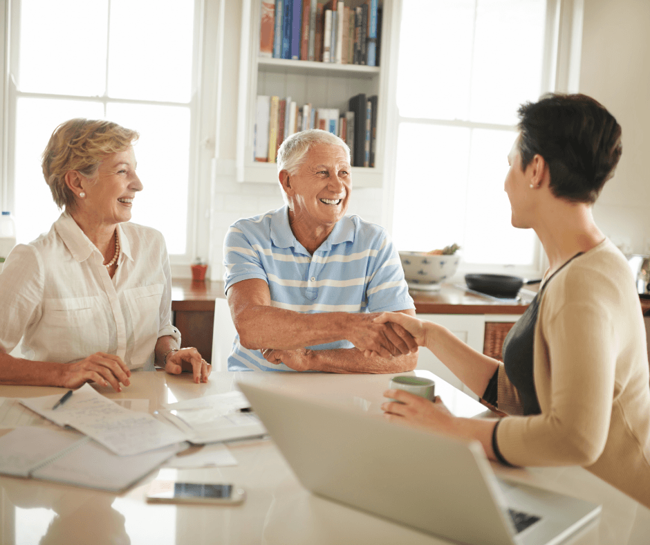 Elders smiling and talking to a caretaker.